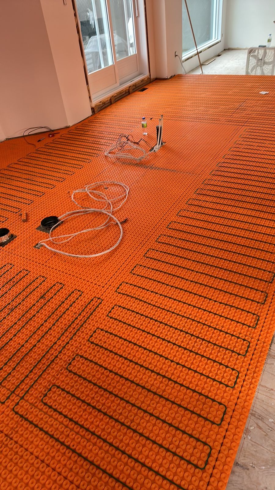 Un grand plancher ouvert avec câble chauffant et fils de sonde prêts pour la céramique