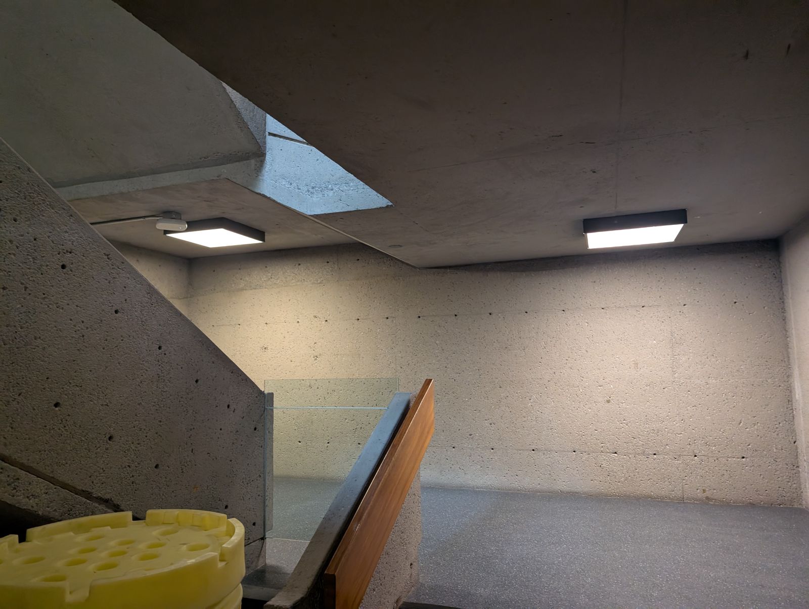 Square LED ceiling fixtures and surface conduit on a concrete ceiling