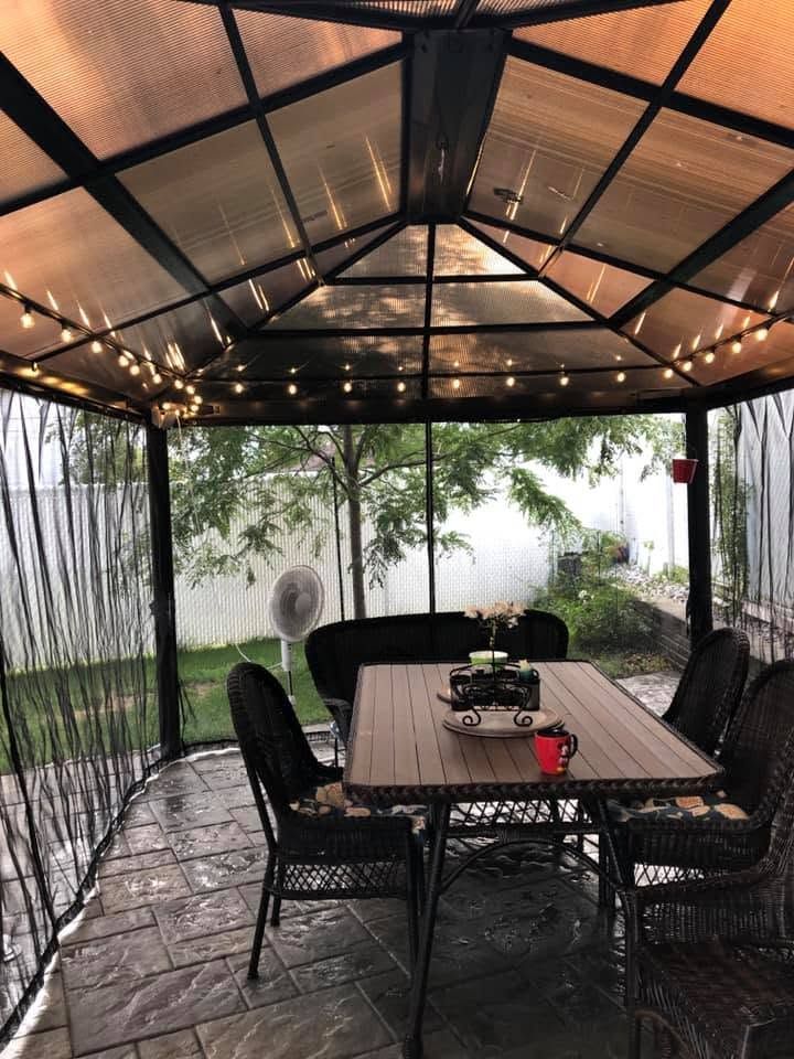 Un gazebo de cour arrière avec éclairage chaleureux en guirlandes et électricité extérieure