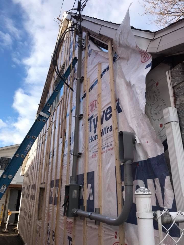 Un nouveau mât de branchement et une base de compteur sur une construction neuve, avant le revêtement