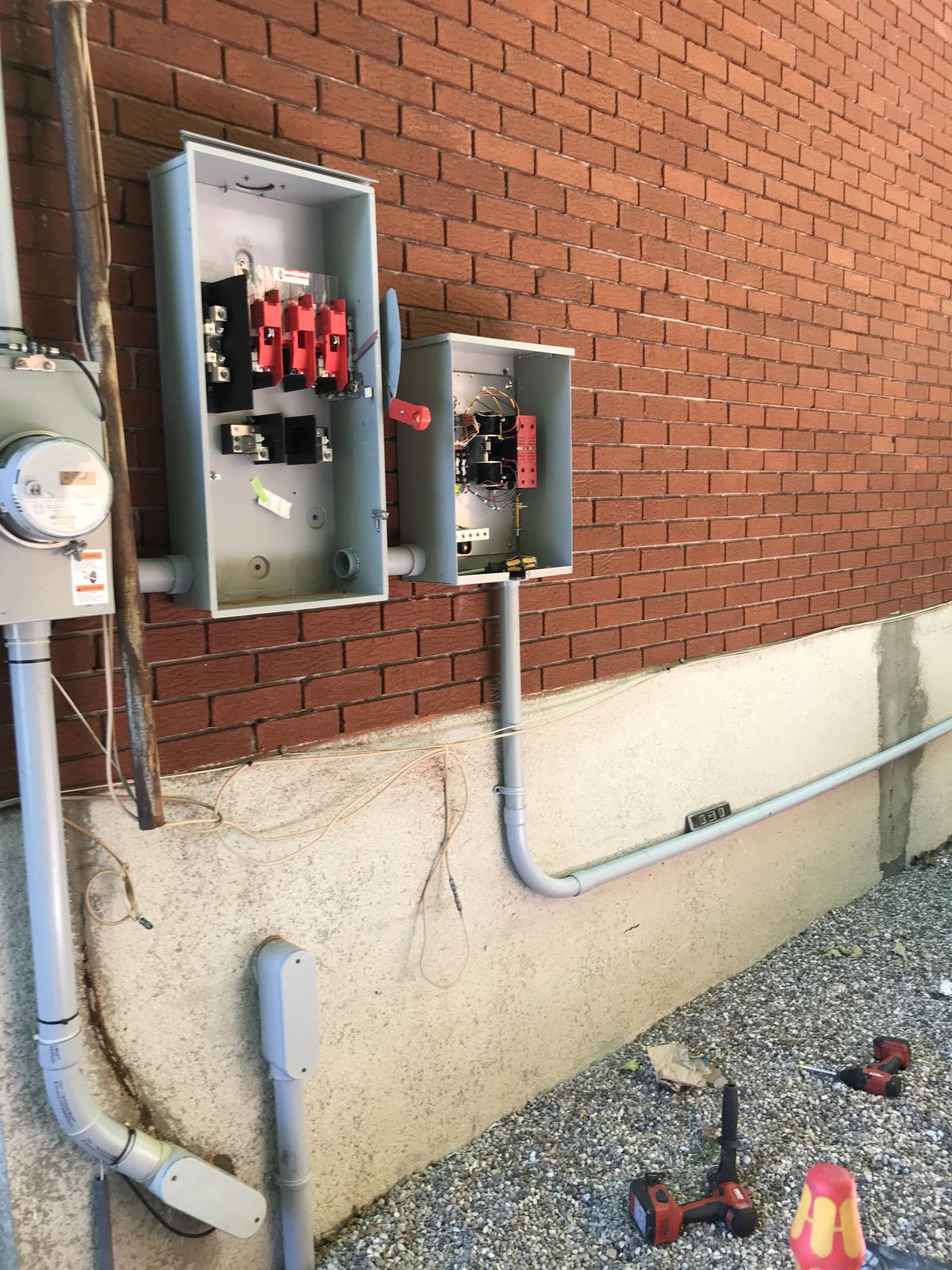 A meter and disconnect switches wired on a brick wall during a generator installation